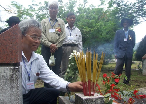 Ông Bùi Đắc Thanh (người ngồi) bên ngôi mộ cha tại nghĩa trang liệt sĩ Hàng Dương. Ảnh: N.Đ.NGỌC