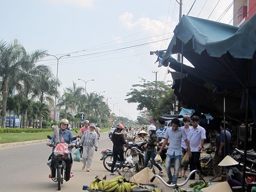 Kẻ bán, người mua lấn chiếm lòng đường và phương tiện đi ngược chiều gây mất ATGT đoạn đường qua trước chợ An Sơn.