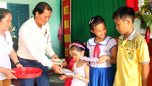 Ông Lê Văn Hữu tặng quà cho con em cựu chiến binh thôn Phú Quý 2. Ảnh: TAM THĂNG