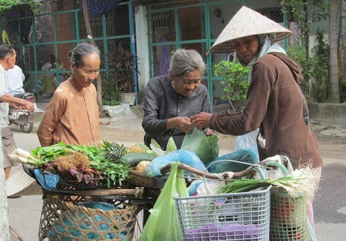 Chị Tiên (bên phải) đưa “chợ” đi khắp các ngã đường để phục vụ khách. Ảnh: H.TÂN