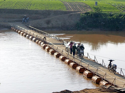 Các bà, các mẹ trở về trên cây cầu sắp hoàn thành sau buổi làm đồng.