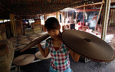 Một cô gái mang những khay nhang vòng để chuẩn bị bán cho dịp Tết ở Tangerang, ngoại ô Jakarta, Indonesia.