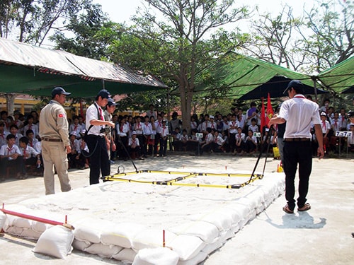 Học sinh thực hành cách rà phá bom mìn. Ảnh: VĂN HÀO