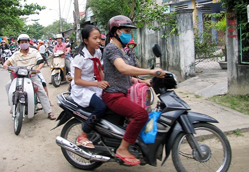 Nhiều phụ huynh vẫn còn thờ ơ với việc đội mũ bảo hiểm cho con em mình.Ảnh: THỤC ANH