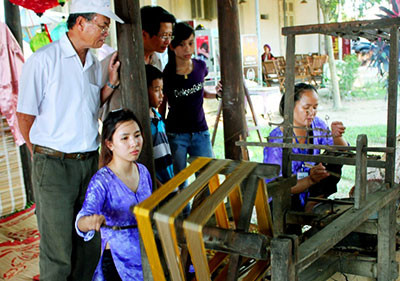 Các nghệ nhân làng lụa Hội An biểu diễn se tơ phụ vụ du khách. 