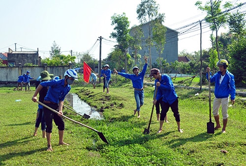 Đoàn viên thanh niên ra quân nạo vét hệ thống thoát nước tại sân vận động xã Bình Tú.Ảnh: MINH TÂN