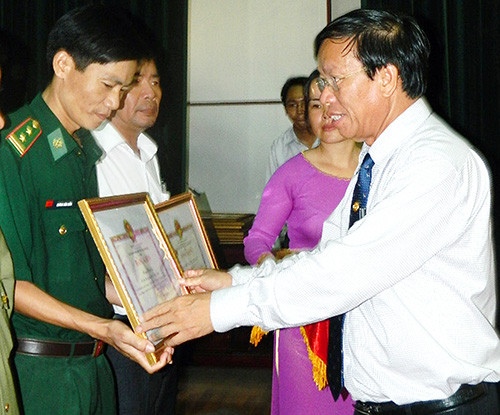Chủ tịch UBND tỉnh Lê Phước Thanh tặng bằng khen cho các tập thể và cá nhân có thành tích xuất sắc.  Ảnh: SONG ANH