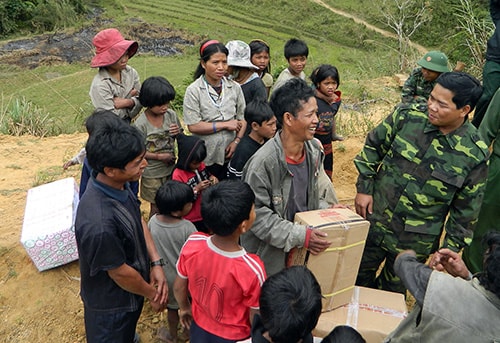 Bộ đội Biên phòng Việt Nam tặng quà nhân dân các cụm bản của Lào ở bên kia biên giới.Ảnh: BRIU QUÂN