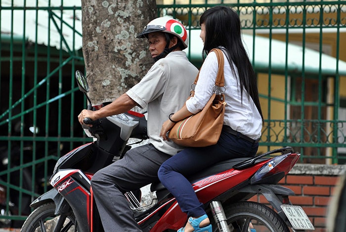 Không chỉ thí sinh, phụ huynh cũng vi phạm luật giao thông khi chở con em mình mà “quên” đội mũ bảo hiểm