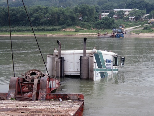 Xe container chúi phần đầu xuống sông.