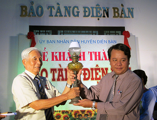 Ông Lê Công Chiêm (bên trái) trao tặng tượng trưng bộ đèn dầu cổ.
