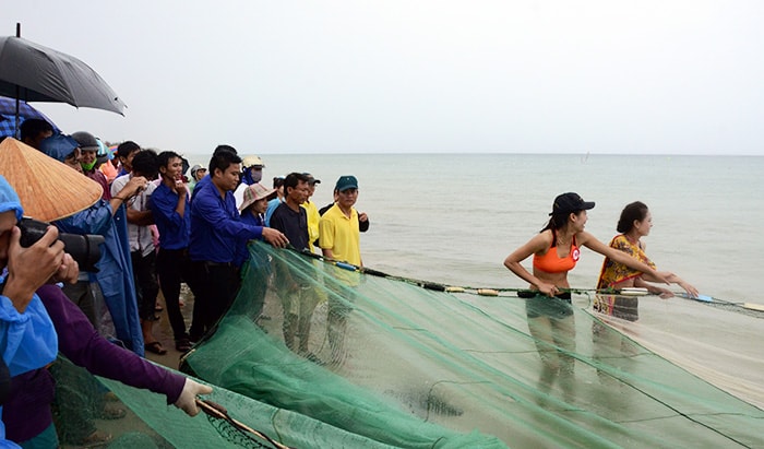 Thí sinh dự thi hoa hậu các dân tộc Việt Nam kéo lưới cùng ngư dân và cùng trổ tài với môn bóng chuyền trên biển. Ảnh: Đăng Khoa