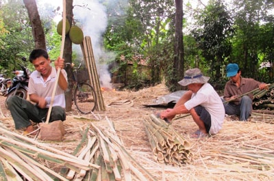 Anh Lương Thế Vĩnh (bên trái) và nhân công vót nan làm vành rổ.Ảnh: Viết Duyên