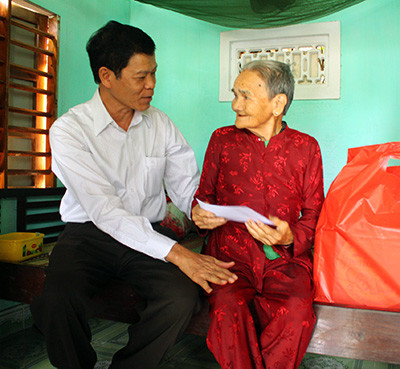 Phó Bí thư Thường trực Tỉnh ủy Nguyễn Văn Sỹ đến thăm, tặng quà bà Mai Thị Thọ ở thôn Câu Nhi Đông, xã Điện An. Ảnh: X.NGHĨA