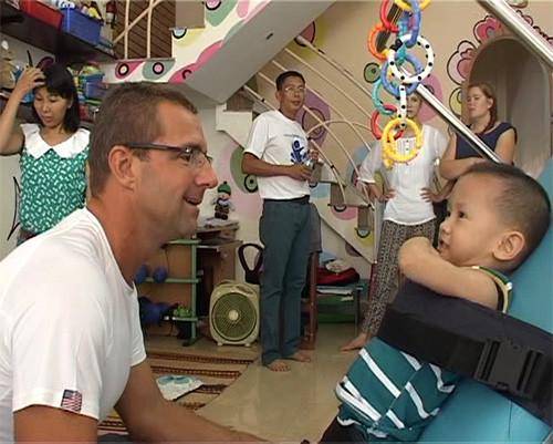 Rudy van Bork làm quen với một trẻ em khuyết tật Việt Nam.
