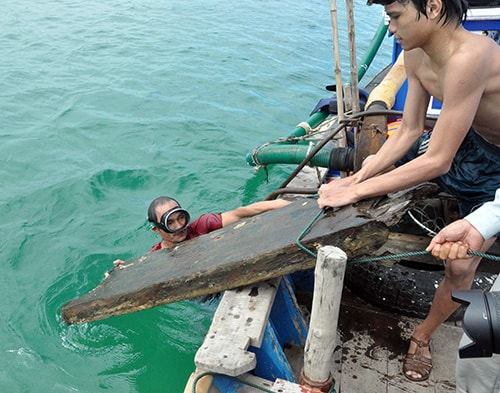 Mảnh ván lớn có thể là từ bộ phận của con tàu cổ được vớt lên khỏi mặt nước. Ảnh: TẤN VỊNH