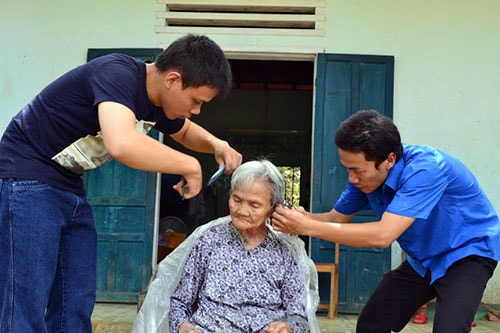 Các bạn trẻ trong Chi hội Nguyện ước xanh cắt tóc cho cụ già tại Trung tâm Dưỡng lão và đào tạo nghề cho người khuyết tật tại Hiệp Đức. Ảnh: NƯX