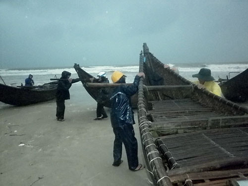 Ngư dân biển Tam Thanh (Tam Kỳ) khẩn trương kéo thuyền vào bờ tránh bão. Ảnh: Nguyễn Dương