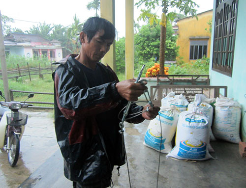 Người dân Điện Quang khẩn trương chèn nhà bằng dây cáp. Ảnh: CÔNG TÚ