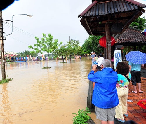 Du khách chụp ảnh lũ tại Hội An.