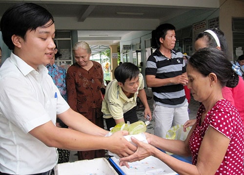 Đoàn viên Chi đoàn khối phố Mỹ Hòa trao những suất cơm miễn phí cho bệnh nhân nghèo.Ảnh: MAI NHI