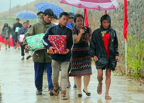 Dân bản Cơ Tu đội mưa che dù đón bạn Lào.