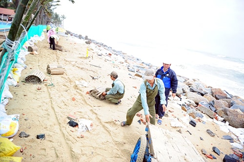 Nhân viên khách sạn Golden Sand gia cố đê. Ảnh: Minh Hải.