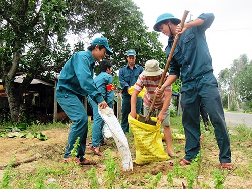 Thanh niên xung kích huyện Duy Xuyên giúp dân chống bão.. Ảnh: Văn Sự.