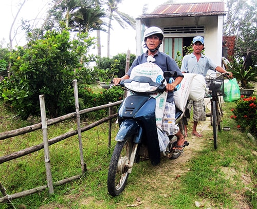 Hơn 20 hộ dân ở thôn Trung Phường (xã Duy Hải, huyện Duy Xuyên) di dời lúa gạo, vật dụng sinh hoạt ra khỏi vùng nguy hiểm. Ảnh: Văn Sự.