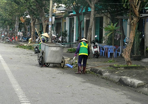 Sau bão, công nhân tích cực dọn dẹp, đảm bảo vệ sinh môi trường. Ảnh: X.HIỀN