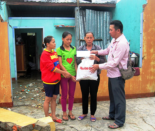 Đại diện Báo Người Lao động tặng quà cho những hộ dân bị bão số 11 gây thiệt hại nặng.