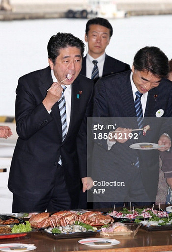 Thủ tướng Nhật Bản (trái) ăn bạch tuộc tại tỉnh Fukushima đê trấn an người tiêu dùng. 