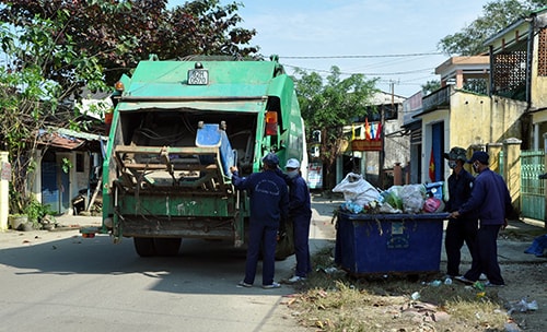 Công nhân của Công ty TNHH một thành viên Môi trường đô thị Quảng Nam thu gom rác thải trên đường phố. Ảnh: T.HỮU