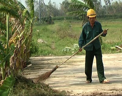  Ông Phạm Thế Mỹ dọn vệ sinh đường làng.