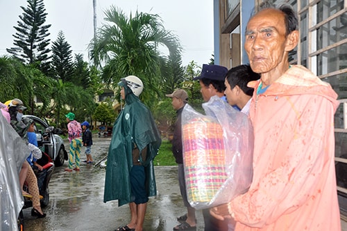 Ông Nguyễn Cao Thiên với các vật dụng “chạy” bão đang đợi xe chở về nhà.  Ảnh: Hữu Phúc