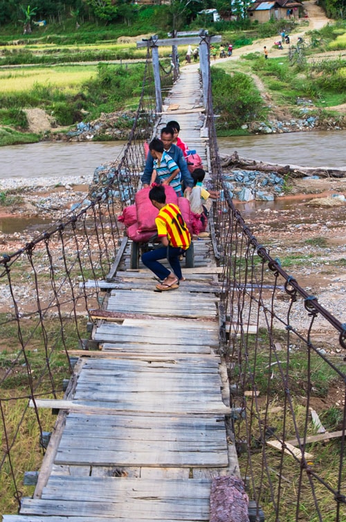 Sau giờ đến trường, trẻ em phụ cha mẹ kéo lúa về nhà.