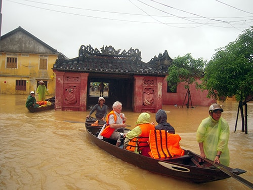 Du khách tránh lũ bằng thuyền có bảo hộ.