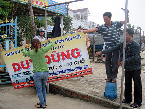 Người dân thị trấn Nam Phước tự tháo dỡ các biển hiệu lắp đặt trái phép trên hành lang đường bộ.