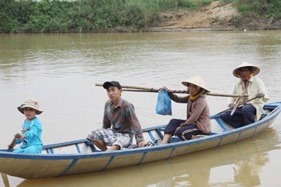 Bà con phải đi bằng ghe sang bên kia sông làm đồng.