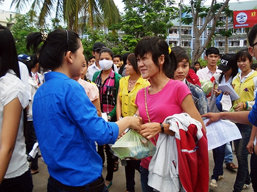 Sinh viên trường ĐH Quảng Nam trao suất ăn miễn phí cho thí sinh trong chương trình Tiếp sức mùa thi. Ảnh: VINH ANH