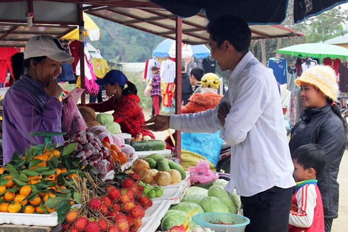 Chị Nga (bên trái) đang bán hàng trái cây  cho khách. Theo chị Nga, càng cận Tết, người mua trái cây càng nhiều khiếnchị thiếu hàng.