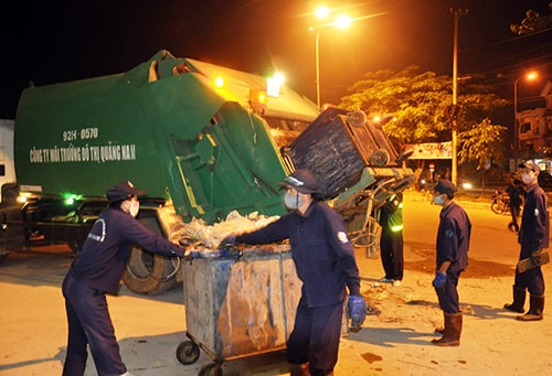 Công nhân của Công ty TNHH MTV Môi trường đô thị Quảng Nam chuyển rác lên xe trung chuyển về bãi tiêu thụ.