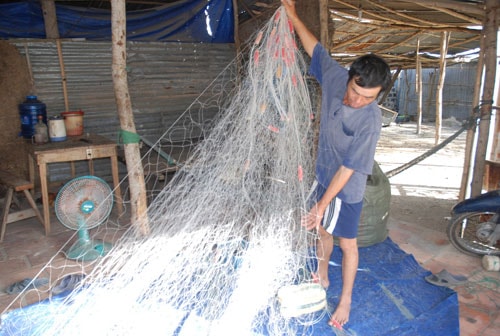 Anh Lê Chí Minh đang kiểm tra lại lưới để sáng mai ra khơi!                                                         ảnh: M.Kiệt