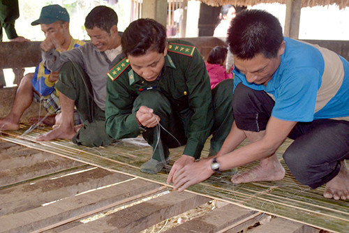 BĐBP giúp nhân dân thôn 49A đang lại sàn nhà Gươl để đón tết Giáp Ngọ.