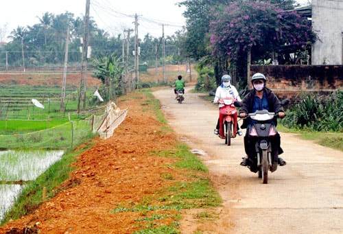 Người dân thôn Thọ Khương tự nguyện hiến đất, hoa màu tạo mặt bằng chuẩn bị bê tông phần mở rộng của tuyến đường liên thôn.  Ảnh: HÀN GIANG