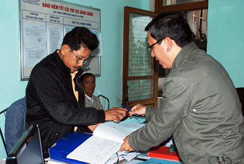 Cán bộ phụ trách công tác người có công ở Phòng LĐ-TB&XH huyện Núi Thành tiếp nhận hồ sơ của công dân. Ảnh: Đoàn Đạo