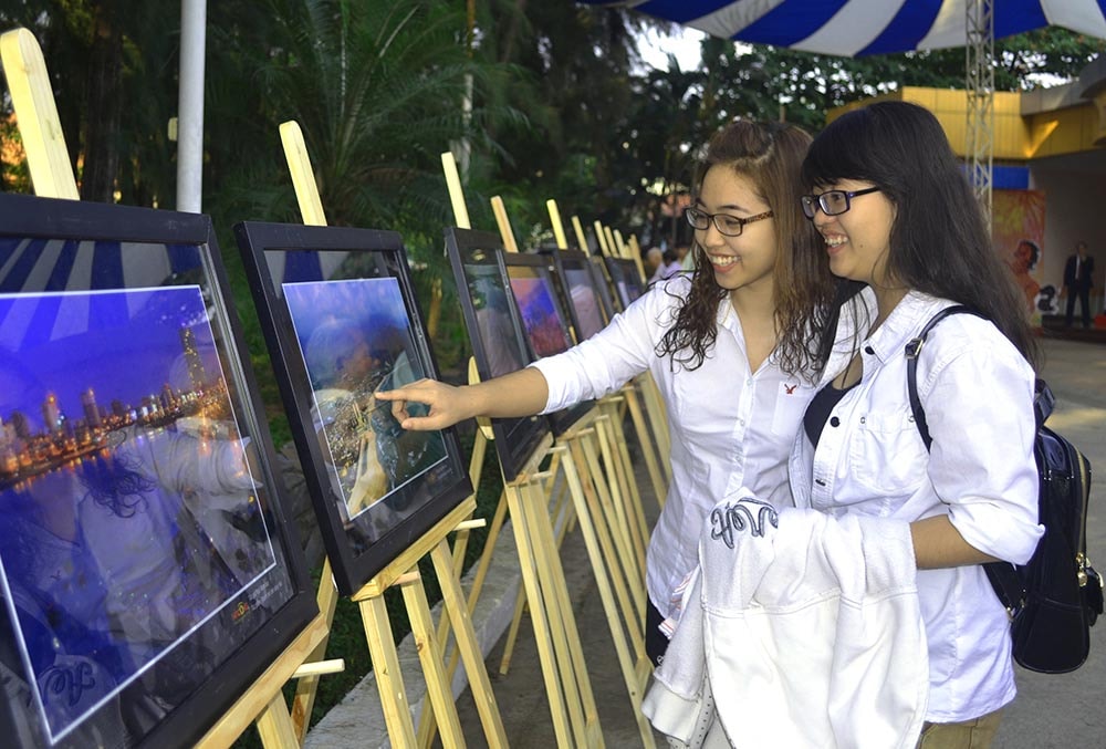 Những sinh viên quê Quảng Nam - Đà Nẵng đang học tập tại TP.Hồ Chí Minh thích thú xem những hình ảnh về quê hương mình. Ảnh: VĂN NỞ