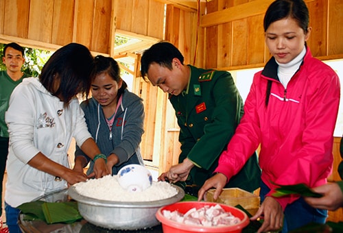 Những nàng dâu biên phòng tham gia gói bánh chưng, chuẩn bị cho ngày tết xa quê. Ảnh: NGUYỄN DƯƠNG