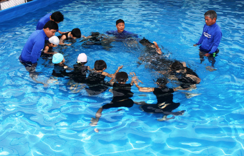 Các huấn luyện viên dạy trẻ các học bơi và an toàn dưới nước.