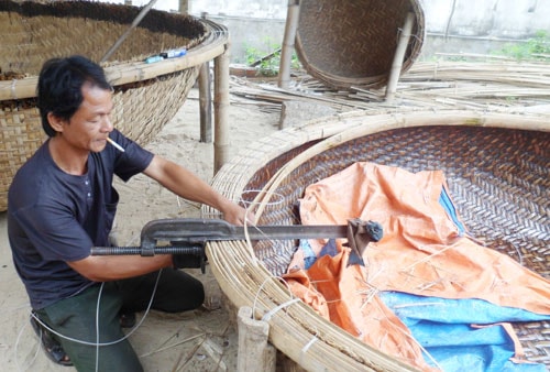 Ông Trần Thái Thanh đang lận vành thúng chai. Ảnh: HOÀNG YÊN